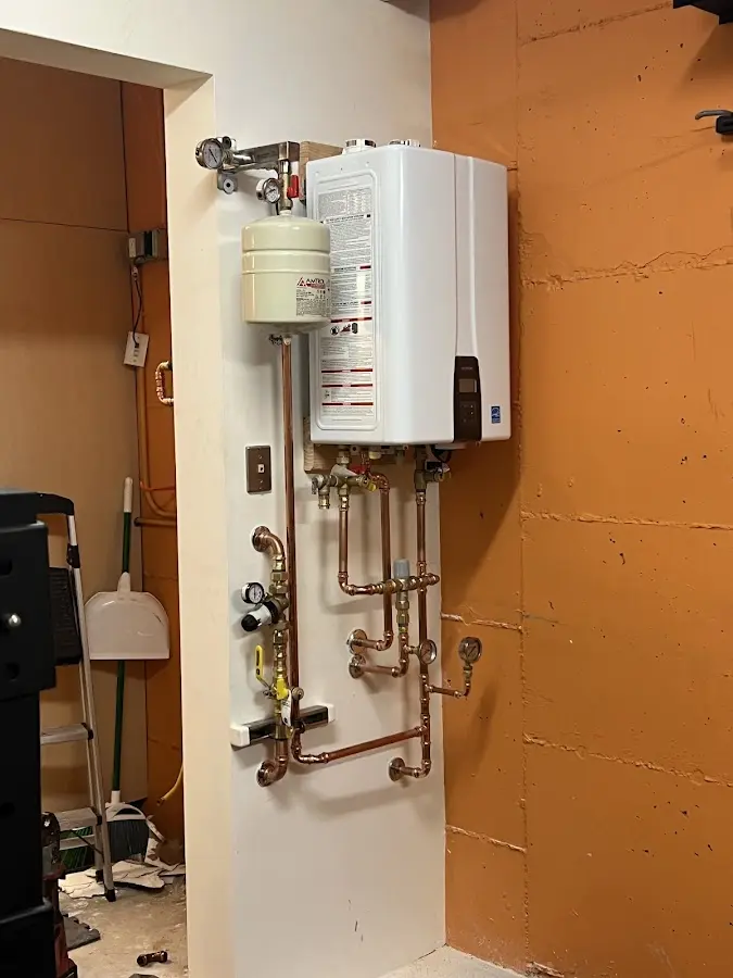 Plumbing technician inspecting water heater connections in Blacksburg